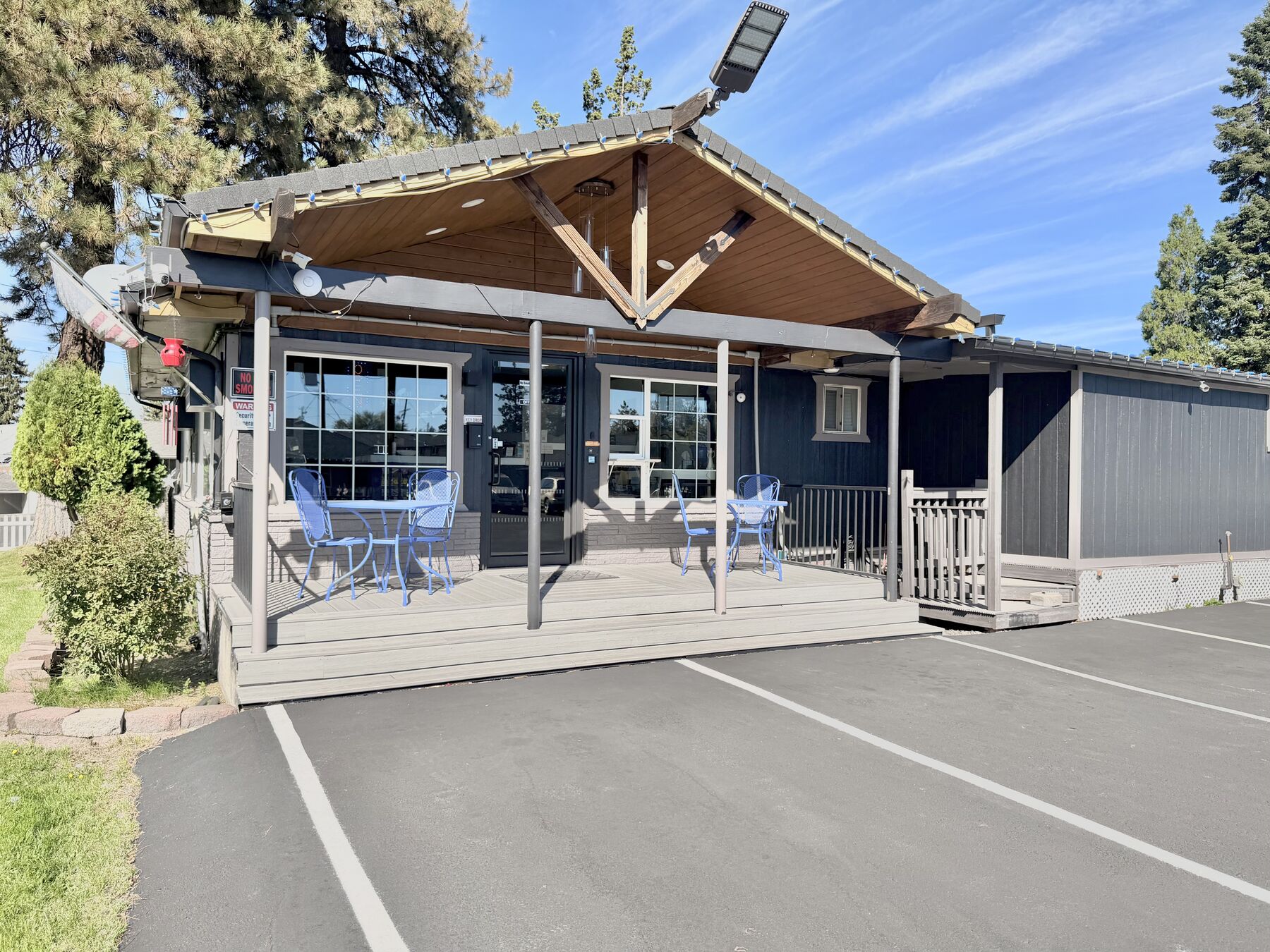 Front office building with a covered porch, patio tables, and large windows