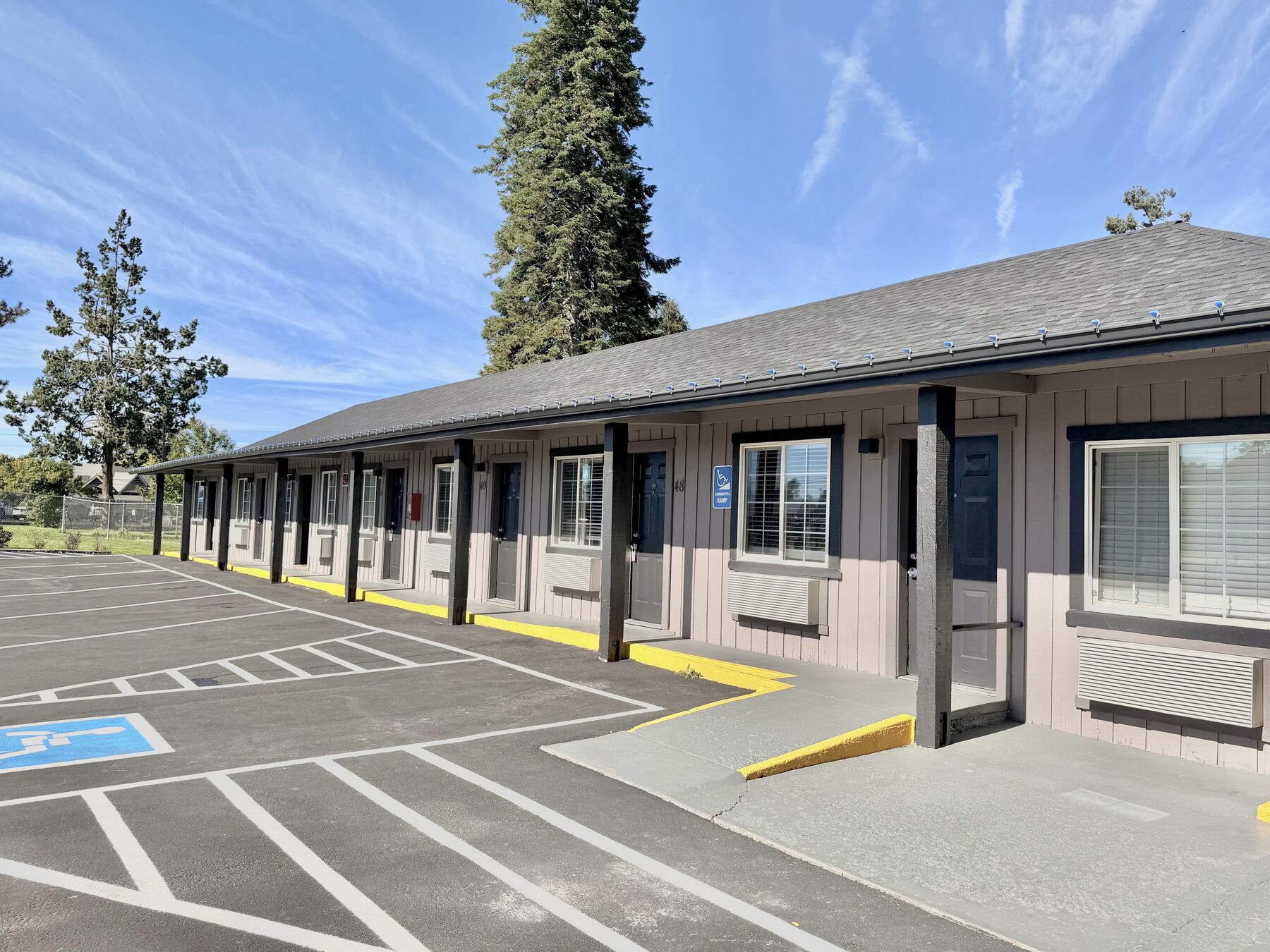 Single-story guest room building with covered walkways and parking at each door