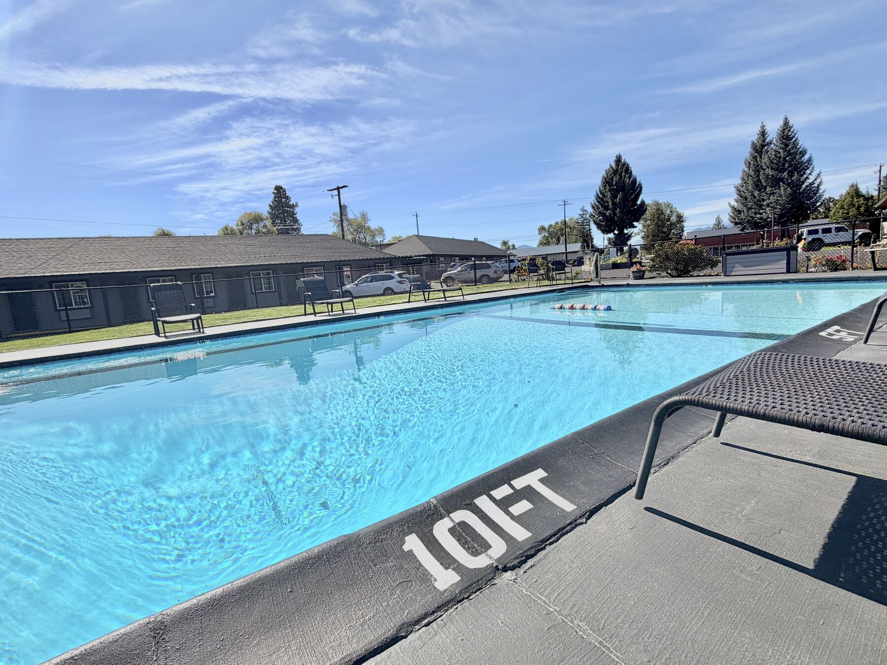 Wide view of the heated outdoor pool showing the 10 ft deep end and poolside lounge chairs