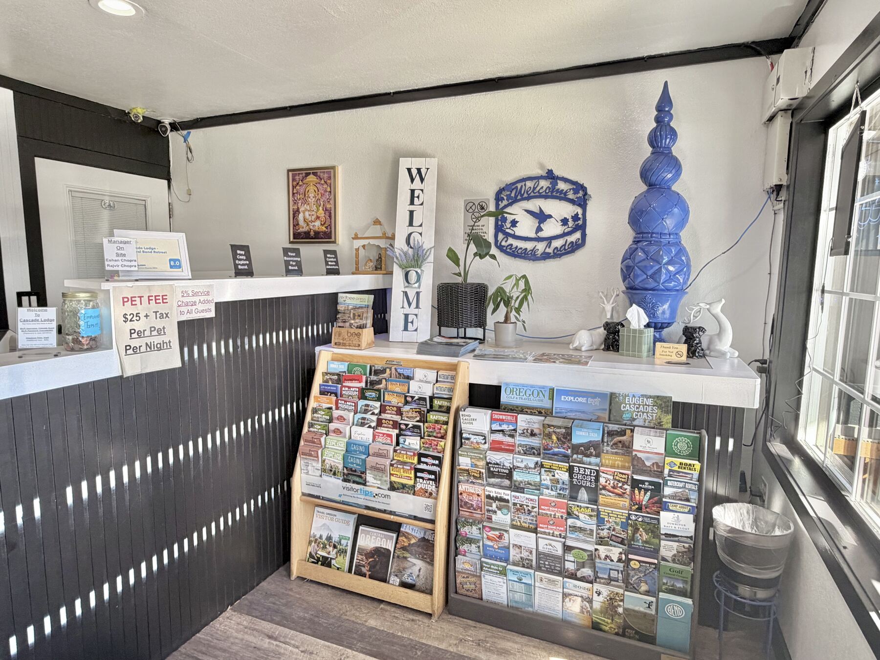 Lobby welcome counter with racks of local brochures and maps, decor, and a Welcome sign