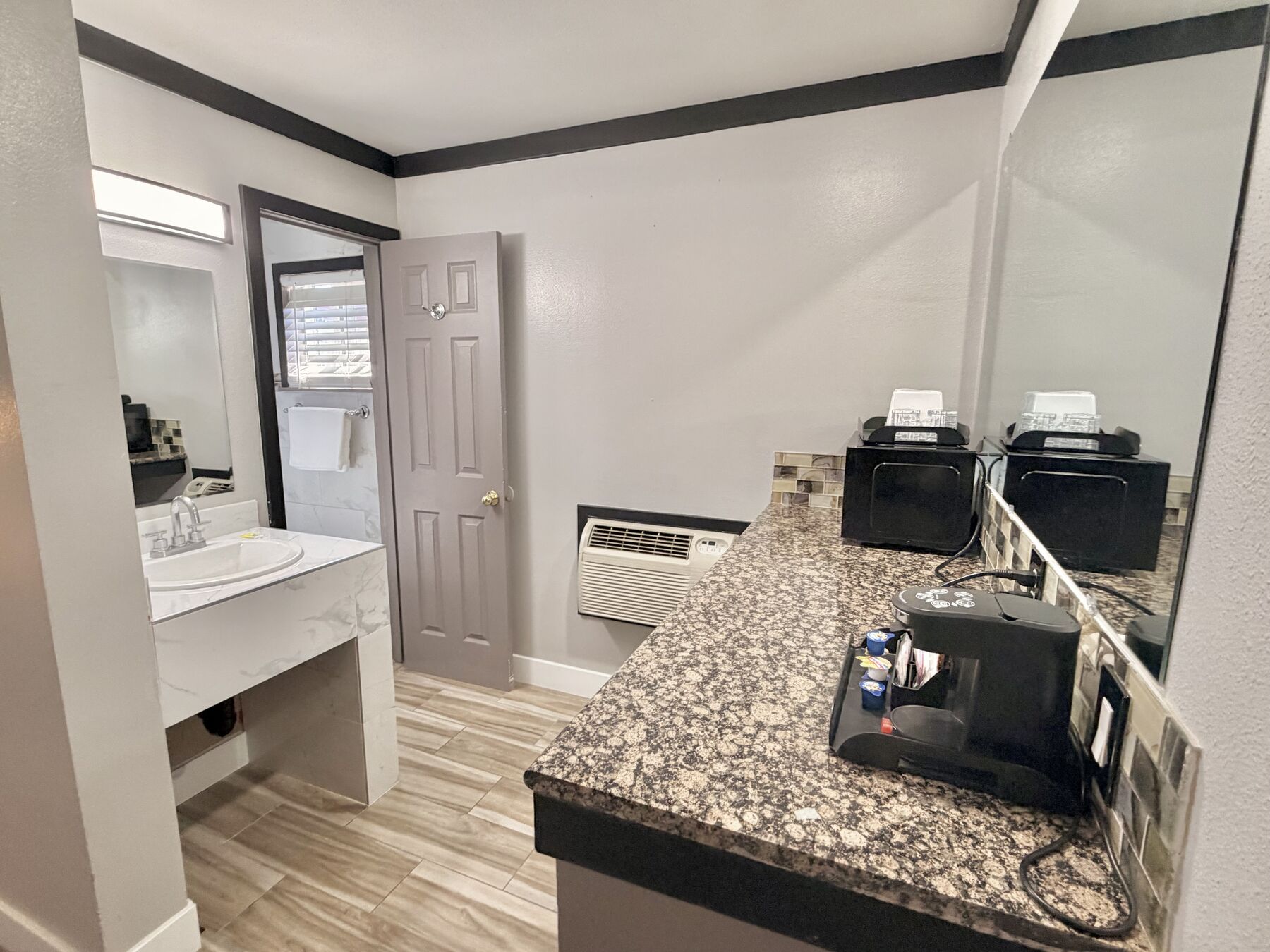 Bachelor King granite counter with mini fridge, microwave, and coffee maker next to the bathroom