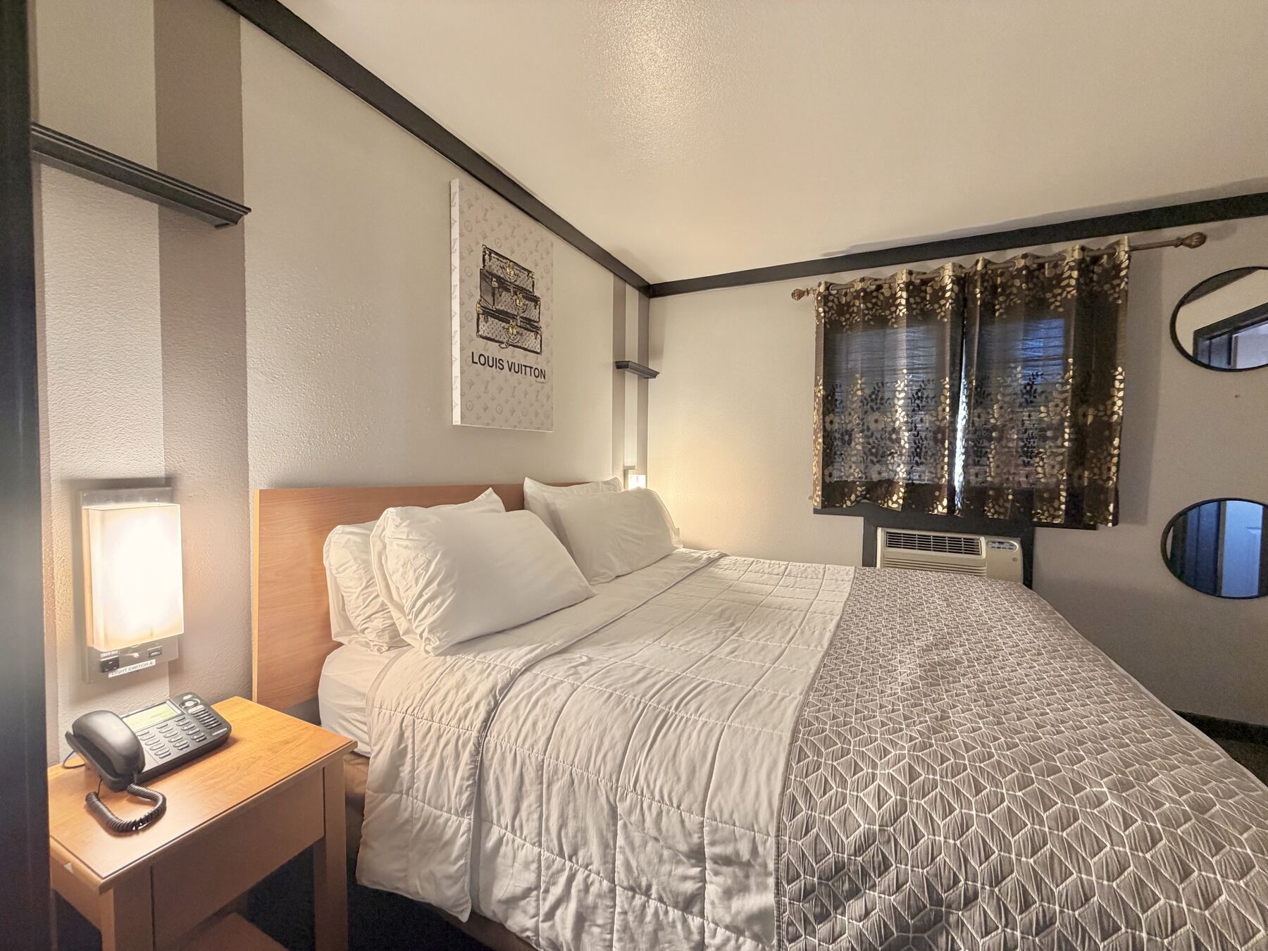 Broken Top King Spa Suite king bed with a wall sconce, bedside phone, and framed art