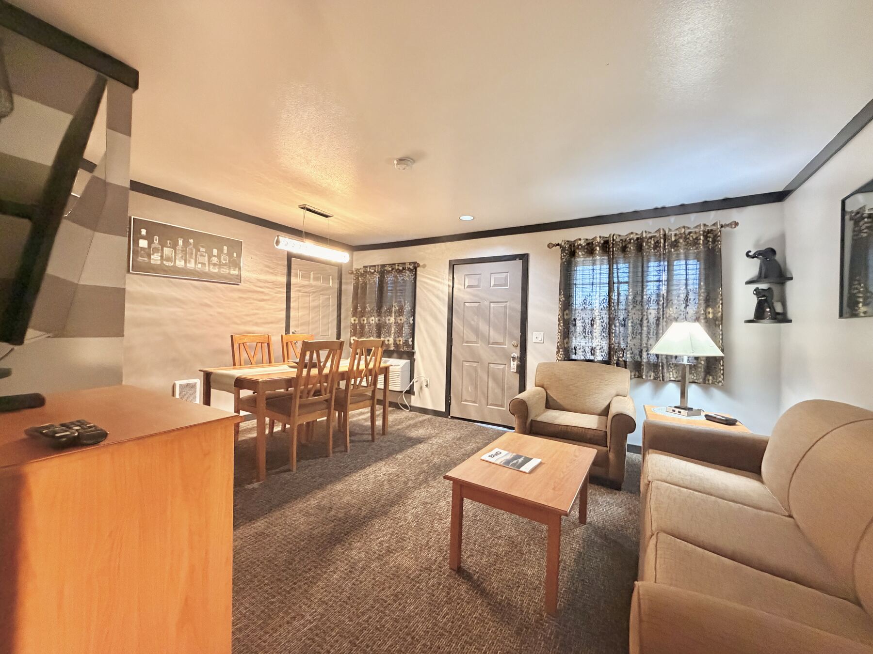 Broken Top King Spa Suite living area with a sofa, armchair, dining table seating four, and the private entry door