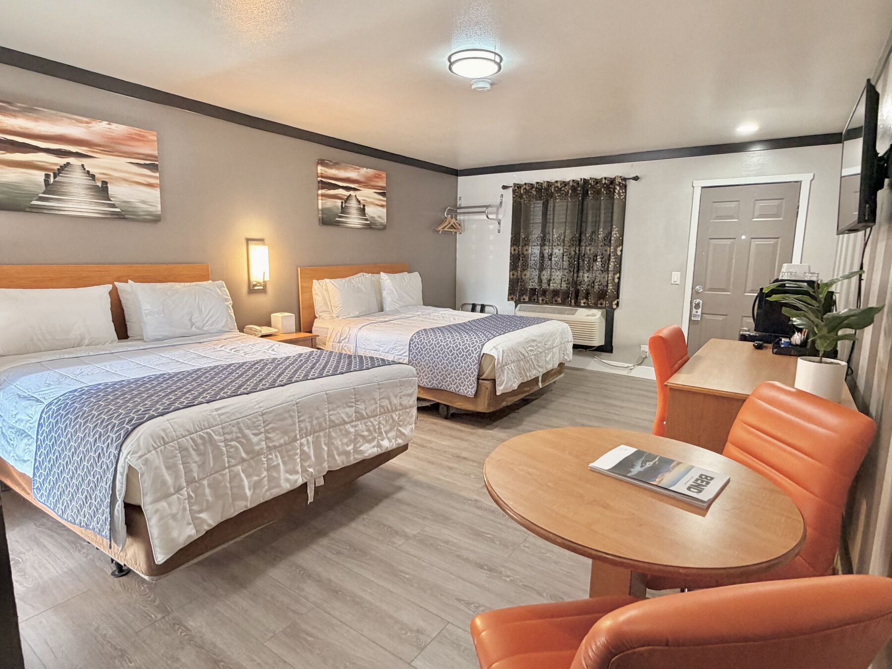 Deschutes Double Queen with two queen beds and coastal wall art, seen from the sitting area