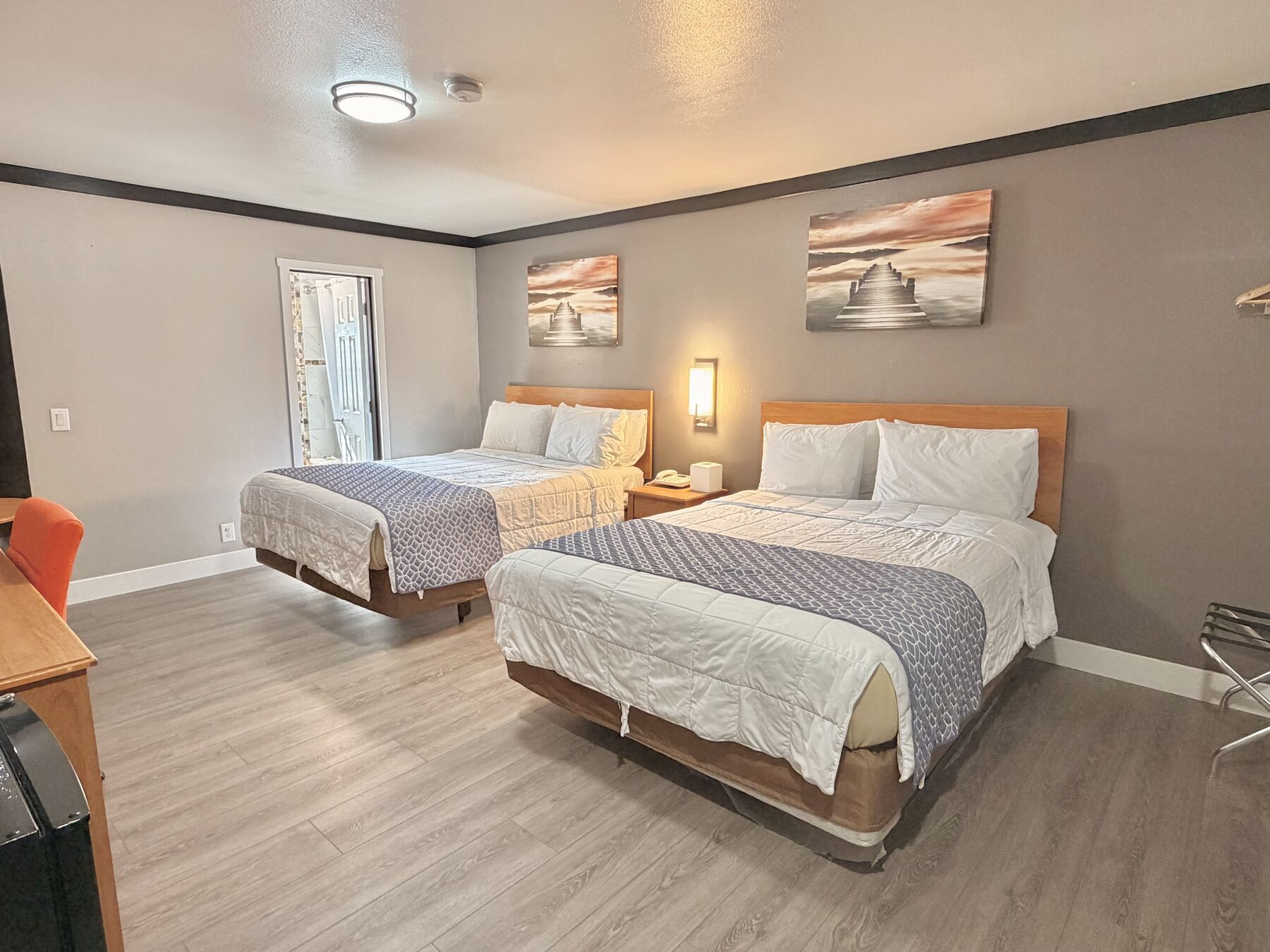 Deschutes Double Queen two queen beds with bedside lamps and framed pier artwork